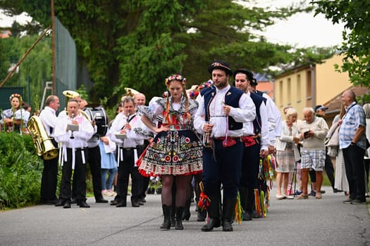 Brno - Bystrc, Czech Republic, 24 June, 2023. Traditional festivities of the feast of the feast in the Czech Republic. Food and drink festival. Girls and boys dancing in beautiful colourful traditional costumes. An old Czech custom of celebrating in villages. 