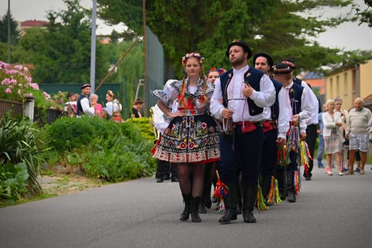 Brno - Bystrc, Czech Republic, 24 June, 2023. Traditional festivities of the feast of the feast in the Czech Republic. Food and drink festival. Girls and boys dancing in beautiful colourful traditional costumes. An old Czech custom of celebrating in villages. 