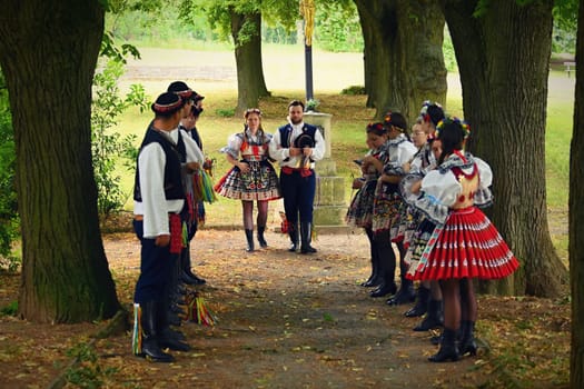 Brno - Bystrc, Czech Republic, 24 June, 2023. Traditional festivities of the feast of the feast in the Czech Republic. Food and drink festival. Girls and boys dancing in beautiful colourful traditional costumes. An old Czech custom of celebrating in villages. 