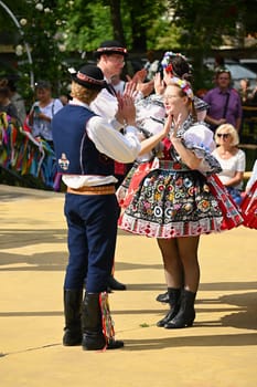 Brno - Bystrc, Czech Republic, 24 June, 2023. Traditional festivities of the feast of the feast in the Czech Republic. Food and drink festival. Girls and boys dancing in beautiful colourful traditional costumes. An old Czech custom of celebrating in villages. 