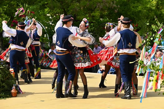 Brno - Bystrc, Czech Republic, 24 June, 2023. Traditional festivities of the feast of the feast in the Czech Republic. Food and drink festival. Girls and boys dancing in beautiful colourful traditional costumes. An old Czech custom of celebrating in villages. 