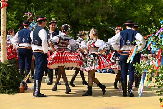 Brno - Bystrc, Czech Republic, 24 June, 2023. Traditional festivities of the feast of the feast in the Czech Republic. Food and drink festival. Girls and boys dancing in beautiful colourful traditional costumes. An old Czech custom of celebrating in villages. 