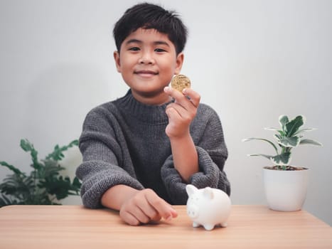 A boy putting coins into piggy bank. Learning financial responsibility and projecting savings. savings concept. investment concept.