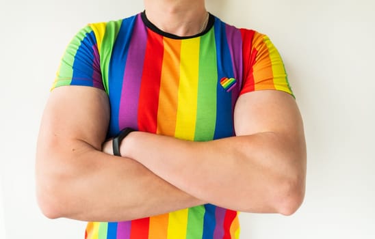 A muscular man in an LGBT T-shirt is standing, hiding his gender identity. LGBT community