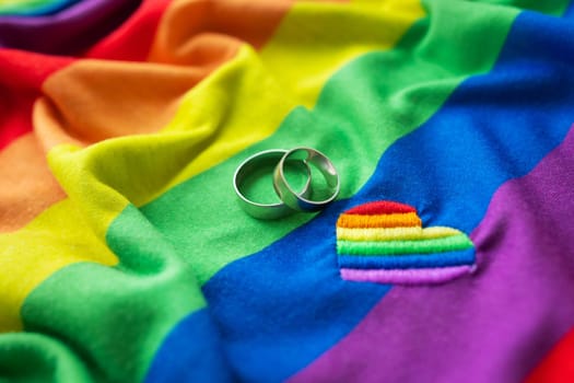 Two wedding rings on a lgbt rainbow flag along with heart embroidered. homosexual marriage. LGBT rights and law. Equal rights for all people on the planet