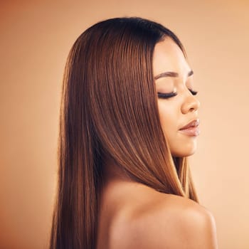 Hair care, beauty and face of woman in studio for wellness, keratin treatment and makeup. Salon, hairdresser and profile of female person on brown background for growth, texture style and cosmetics.