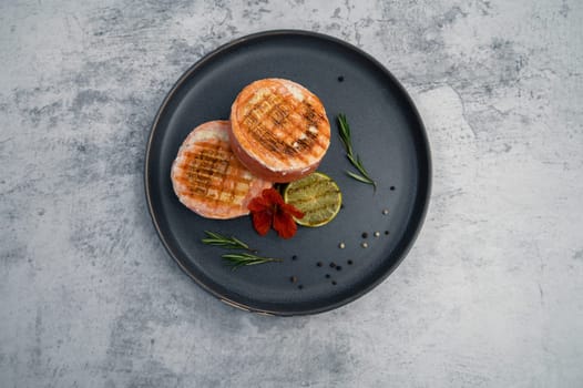 Grilled salmon roll with mozzarella. Decorated with greens lime and edible flower