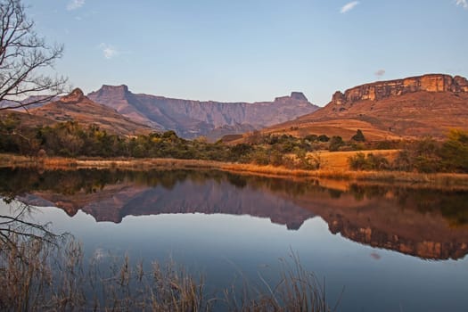 Early morning reflections of the Amohitheatre formation in a calm Drakensberg lake in Royal Natal National Park. KwaZulu-Natal. South Africa