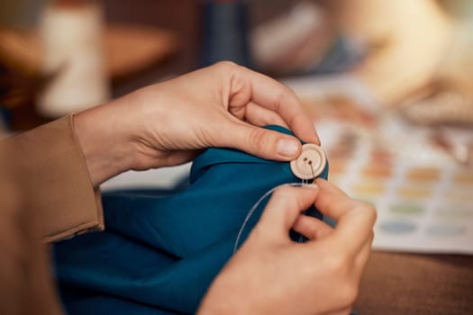 Womab, hands and sewing clothes button in studio for designer wear, fashion garment and creative fabric design. Tailor, boutique startup and fashion designer hand or seamstress working on clothing.