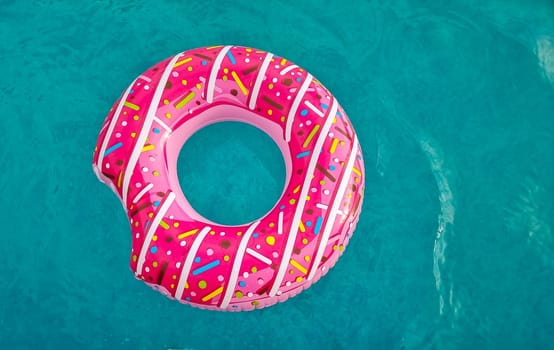 Yellow inflatable ring floating in swimming pool. Vacation concept with copy space