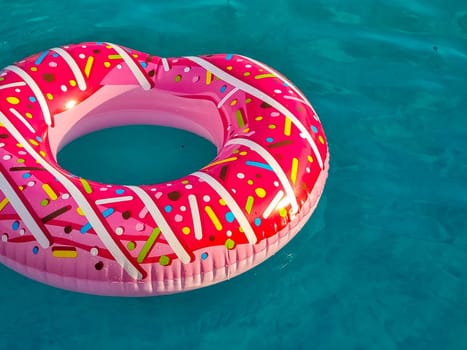 Yellow inflatable ring floating in swimming pool. Vacation concept with copy space