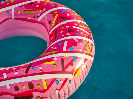 Yellow inflatable ring floating in swimming pool. Vacation concept with copy space