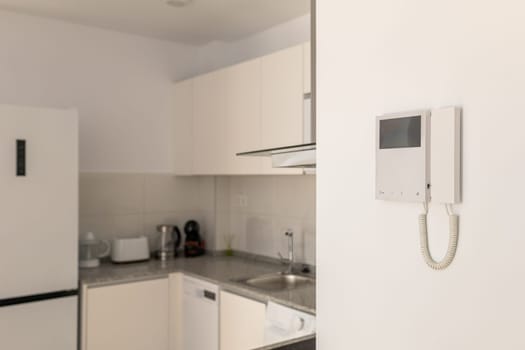 Blurred Ivory color kitchen island set next to refrigerator and intercom. The concept of versatility and convenience in a compact studio apartment. Copyspace.