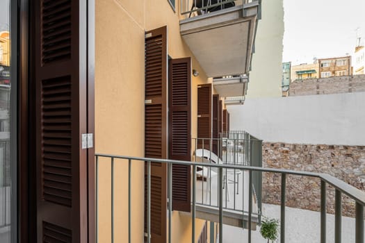 Access to an open loggia balcony in an apartment building with tables and chairs for a fresh air without leaving the house. The concept of comfortable modern housing.