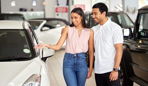 Couple at car dealership, choice and transport with smile, people buying new vehicle with luxury and customer. Happy with decision, man and woman at automobile showroom, purchase and transportation.