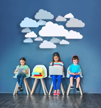 Enhancing the learning process with modern tech. Studio shot of kids sitting on chairs and using wireless technology with clouds above them against a blue background