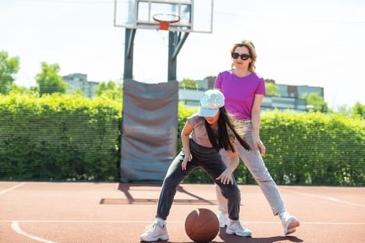 Mother and daughter playing basketball.