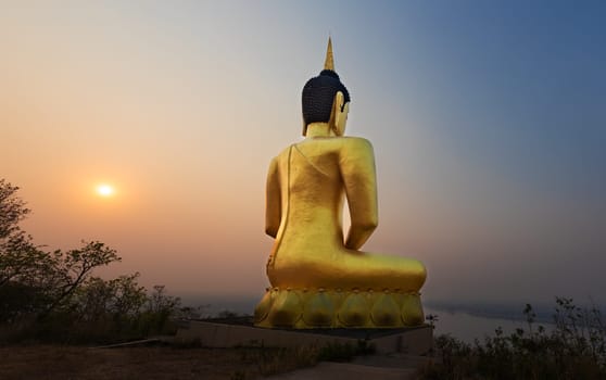 Golden Buddha overlooking Pakse at sunset. Wat Phousalao. Laos
