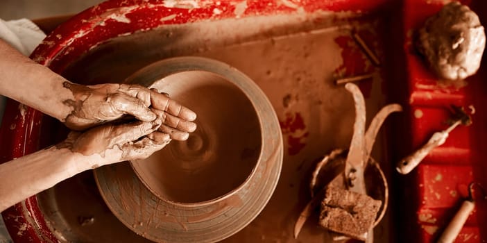 Getting my hands dirty is my favorite part. an unrecognizable woman molding clay on a pottery wheel