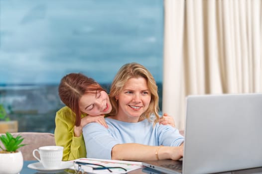 Mother with daughter working from home. Businesswoman mother woman with daughter trying to working. home office, remote work, mom while working from home concept