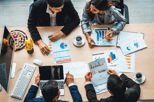 Business people group meeting shot from top view in office . Profession businesswomen, businessmen and office workers working in team conference with project planning document on meeting table . Jivy