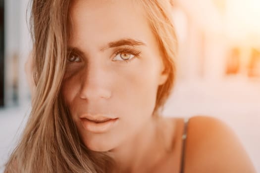 Happy woman portrait in cafe. Boho chic fashion style. Outdoor photo of young happy woman with long hair, sunny weather outdoors sitting in modern cafe