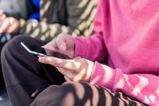 close up of the hand of a young man using mobile phone to scroll through social media, concept of technology of communication and modern lifestyle