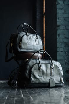 two different size black leather travel bags, indoors photo on black background