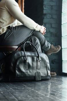 a man with a bag. black leather travel bag, indoors photo on black background.