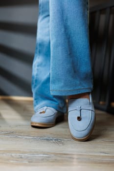 Slender female legs in jeans and blue loafers. Collection of summer women's shoes. Stylish women's shoes for summer