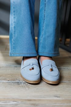 Slender female legs in jeans and blue loafers. Collection of summer women's shoes. Stylish women's shoes for summer