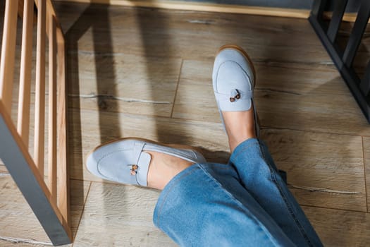Slender female legs in jeans and blue loafers. Collection of summer women's shoes. Stylish women's shoes for summer