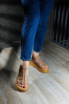 Women's sandals. Female feet close-up in casual brown sandals. Collection of summer women's sandals