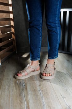 Summer women's sandals. Collection of women's leather summer sandals. Slender female legs in beige leather sandals without heels.