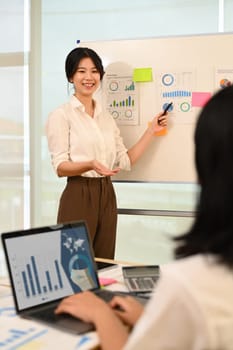 Young businesswoman giving presenting sales report, marketing strategy, project plan at corporate meeting.