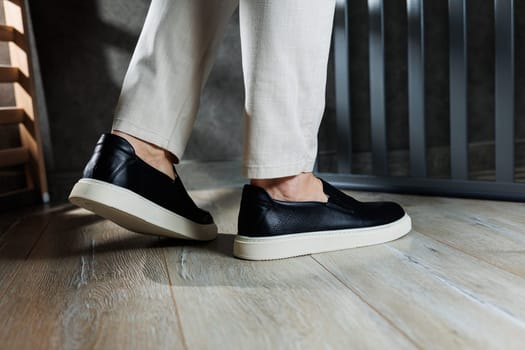 Male legs in leather shoes. Comfortable men's black shoes without laces. Casual men's moccasins