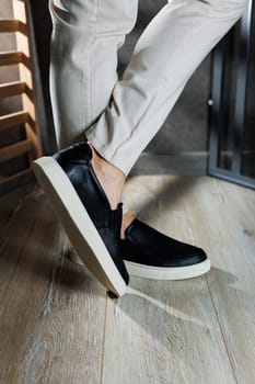 Male legs in leather shoes. Comfortable men's black shoes without laces. Casual men's moccasins