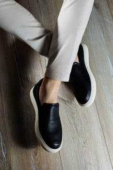 Male legs in leather shoes. Comfortable men's black shoes without laces. Casual men's moccasins