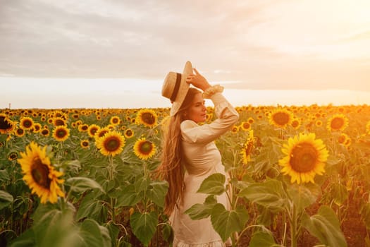 Woman in the sunflowers field. Summer time. Young beautiful woman standing in sunflower field.