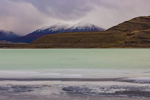 Deep clouds over the mountains at Torres del Paine National Park at the saline Laguna Amarga before sunrise, Chile, Patagonia, South America