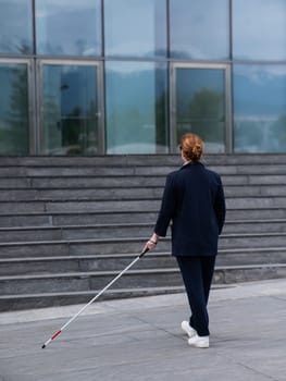 Blind businesswoman walking with tactile cane to business center