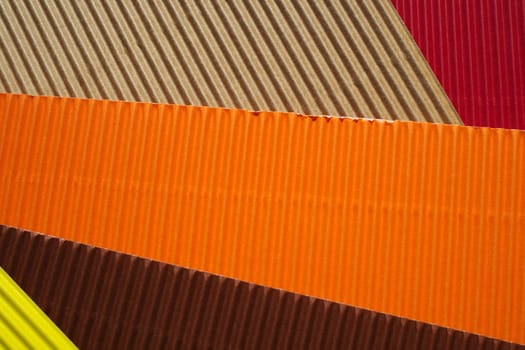 Diagonally ribbed cardboard with the colors beige, red, orange, brown and yellow. Meant as background