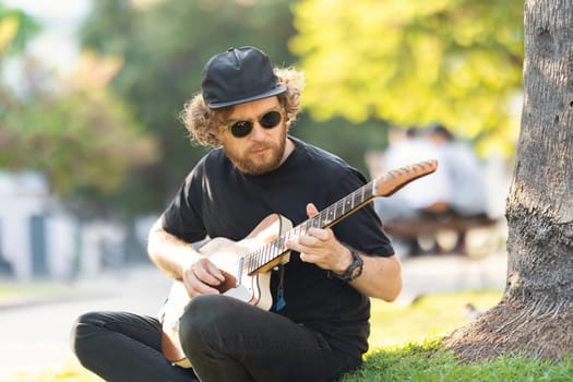 Man playing guitar on the street. Mid shot