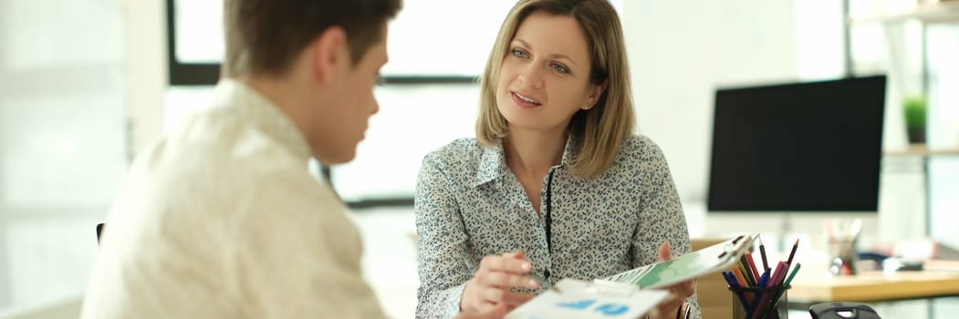 Business partners studying information on documents with charts in office. Business meeting concept