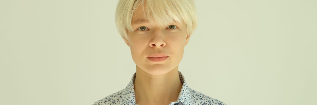 Portrait of young blonde woman with short haircut in shirt on white background. Stylish female hairstyles concept