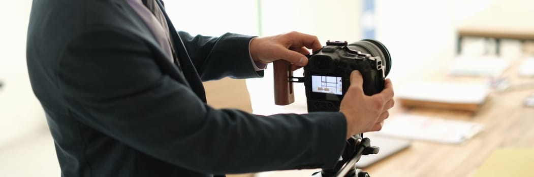 Man in suit business blogger adjusting camera in conference room. Business education online concept