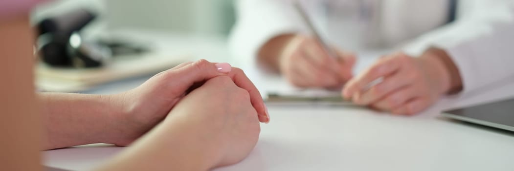 Patient hands on table during visit to doctor in clinic closeup. Medicare concept