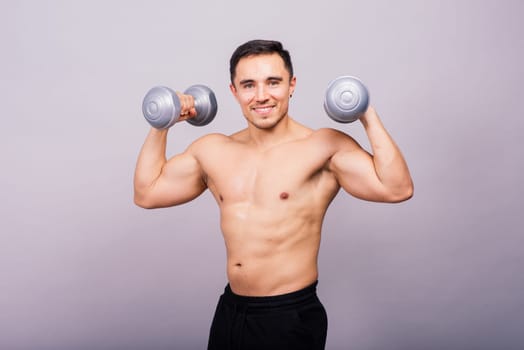 Shirtless bodybuilder showing his great body and holding dumbells.