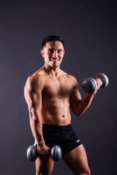 Shirtless bodybuilder showing his great body and holding dumbells.