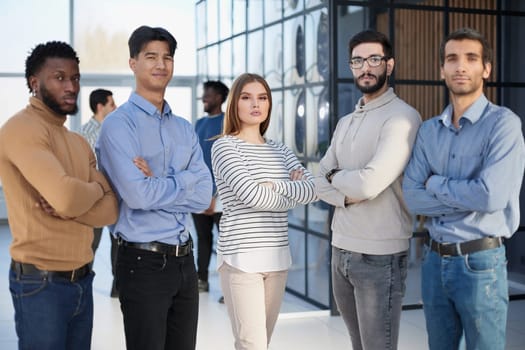 Group of successful businesspeople standing in row and looking at camera at office